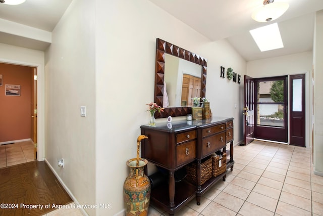 foyer with a skylight and light tile patterned flooring