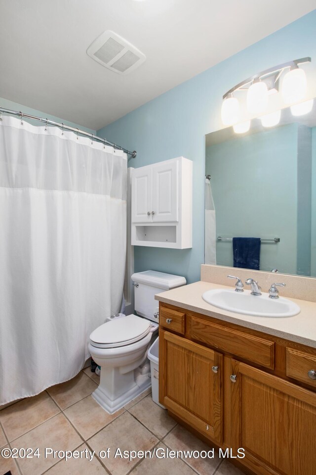 bathroom with tile patterned flooring, vanity, and toilet