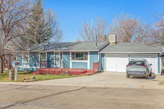 ranch-style house with a chimney, an attached garage, cooling unit, and concrete driveway