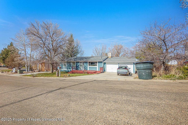 ranch-style home featuring concrete driveway and a garage