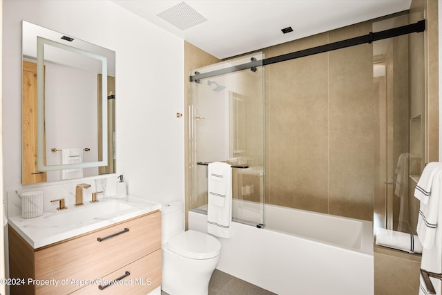 full bathroom with combined bath / shower with glass door, vanity, and toilet