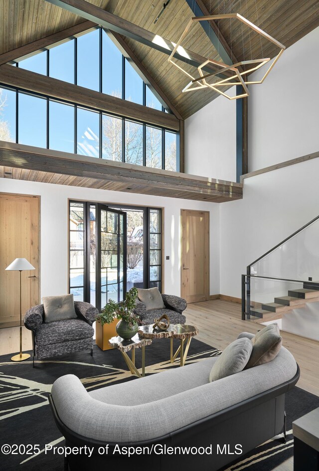 living room with a fireplace, a towering ceiling, and light hardwood / wood-style floors