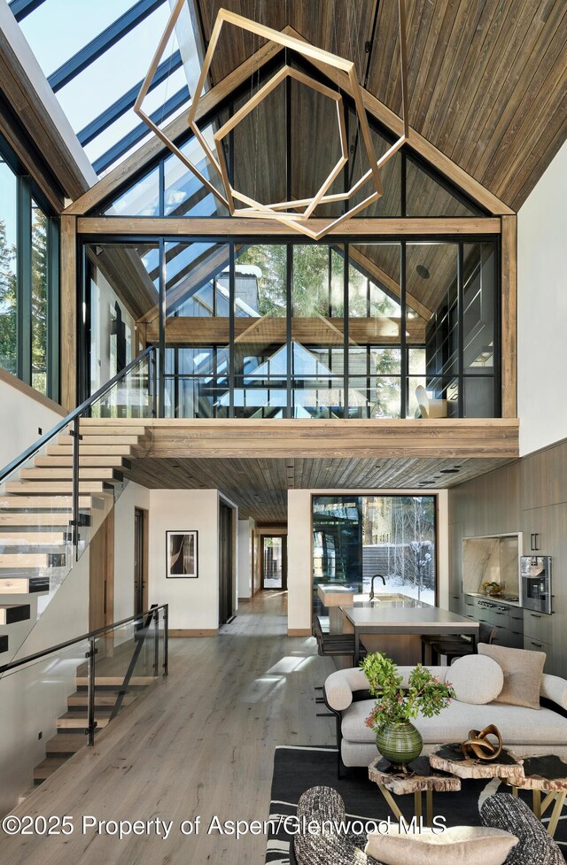 dining room featuring wooden ceiling, sink, high vaulted ceiling, and light hardwood / wood-style floors