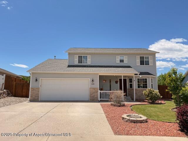 80 Cliff View Cir, Parachute, CO 81635 - traditional home with covered porch, brick siding, concrete driveway, and a garage