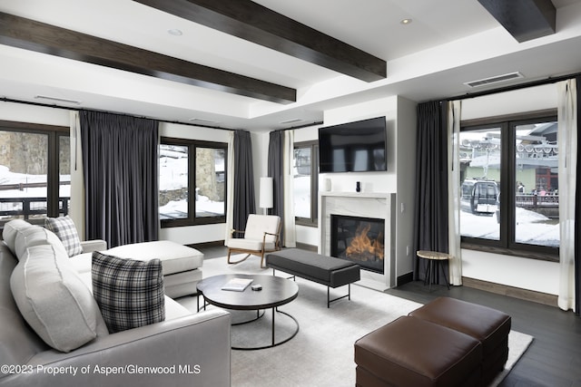 living room featuring wood-type flooring, beam ceiling, and a premium fireplace