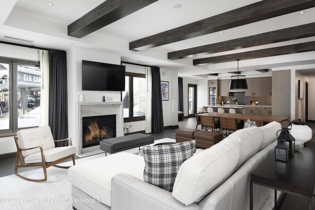 living room with beamed ceiling and a premium fireplace