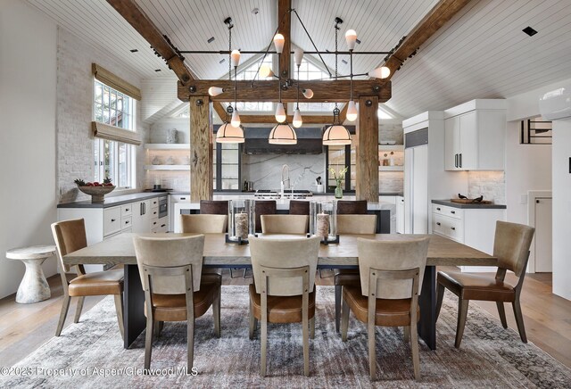 1271 Ute Ave, Aspen, CO 81611 - dining space with light wood-style flooring, high vaulted ceiling, beam ceiling, and a chandelier