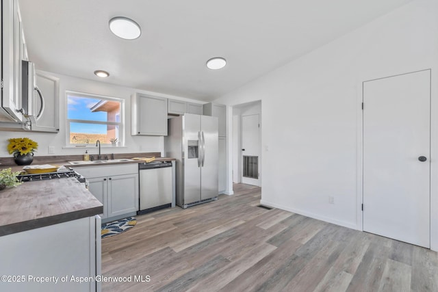 kitchen with light wood-style floors, visible vents, stainless steel appliances, and a sink