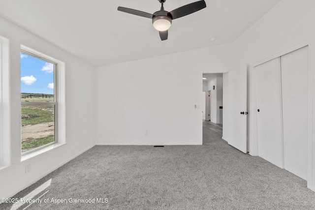 unfurnished bedroom with carpet floors, multiple windows, and a closet