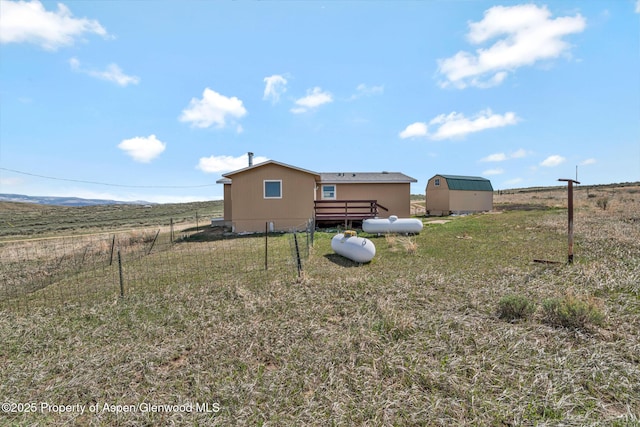 exterior space with fence, an outbuilding, a yard, and a storage shed