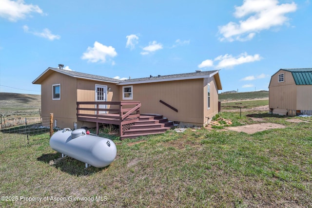 back of property with a yard, crawl space, fence, and a deck