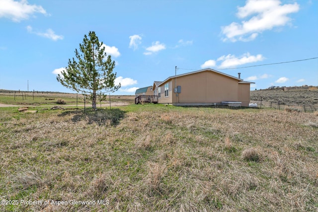 view of yard featuring a rural view and fence