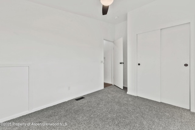 unfurnished bedroom with a ceiling fan, visible vents, carpet, and a closet