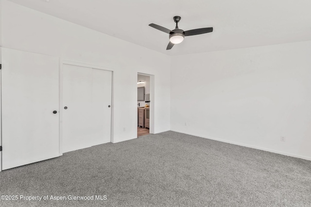 unfurnished bedroom featuring carpet, a closet, baseboards, and ensuite bathroom