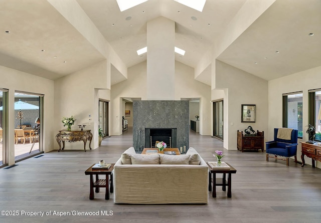 3333 Snowmass Creek Rd, Snowmass, CO 81654 - living room featuring a skylight, high vaulted ceiling, wood finished floors, and a premium fireplace