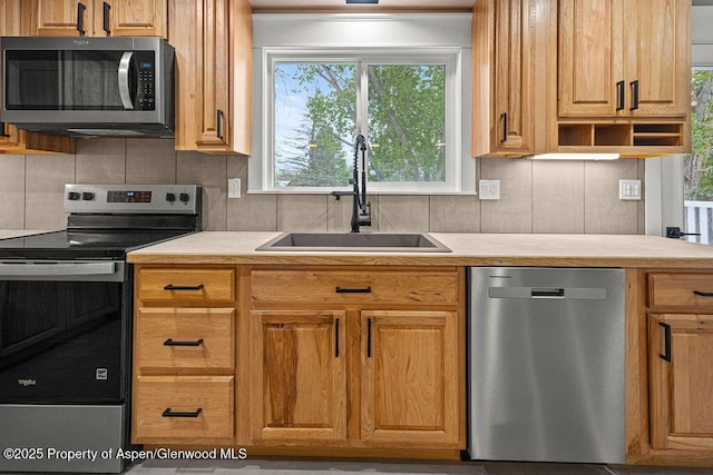 885 Stout St, Craig, CO 81625 - kitchen with appliances with stainless steel finishes, a sink, light countertops, and tasteful backsplash
