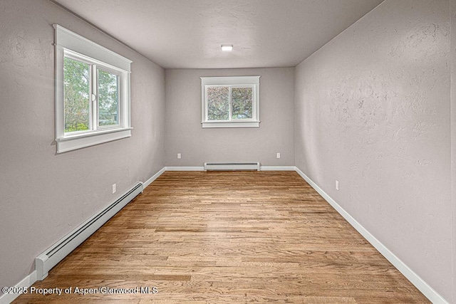 885 Stout St, Craig, CO 81625 - empty room with baseboard heating, wood finished floors, baseboards, and a textured wall