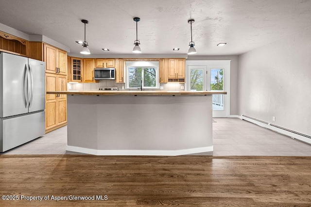 885 Stout St, Craig, CO 81625 - kitchen featuring appliances with stainless steel finishes, a baseboard radiator, light countertops, glass insert cabinets, and a textured ceiling