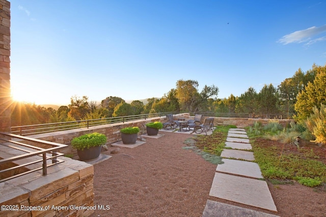 yard at dusk featuring a patio area