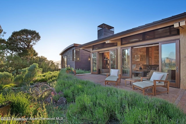 back house at dusk with a patio