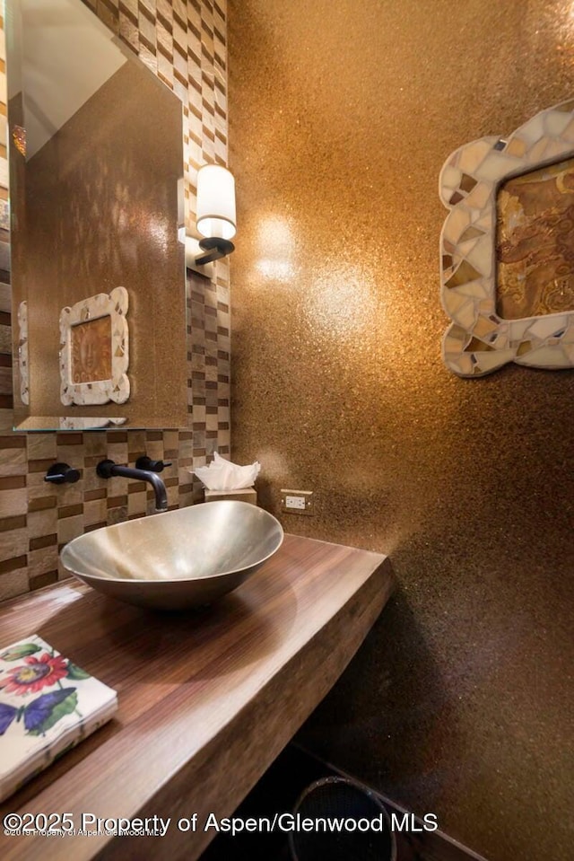 bathroom featuring sink and backsplash