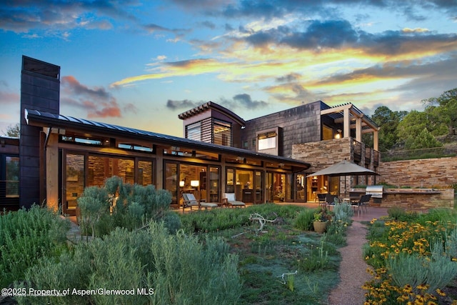 view of back house at dusk