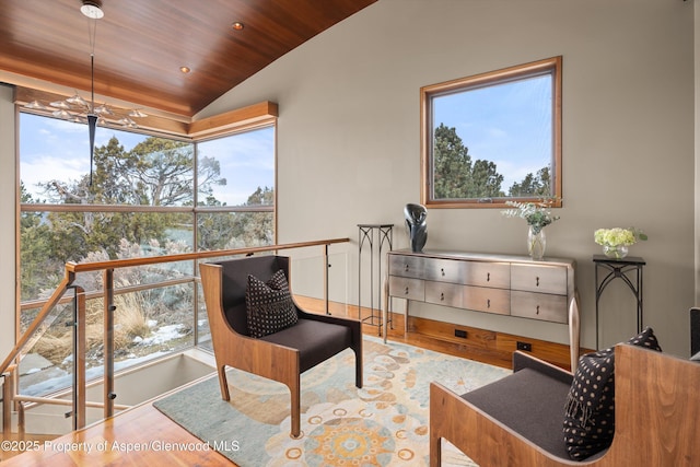 living area featuring vaulted ceiling, wood-type flooring, and wood ceiling