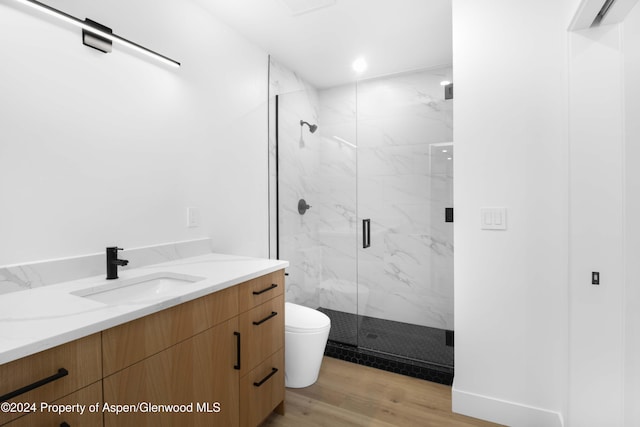 bathroom with hardwood / wood-style floors, vanity, toilet, and an enclosed shower