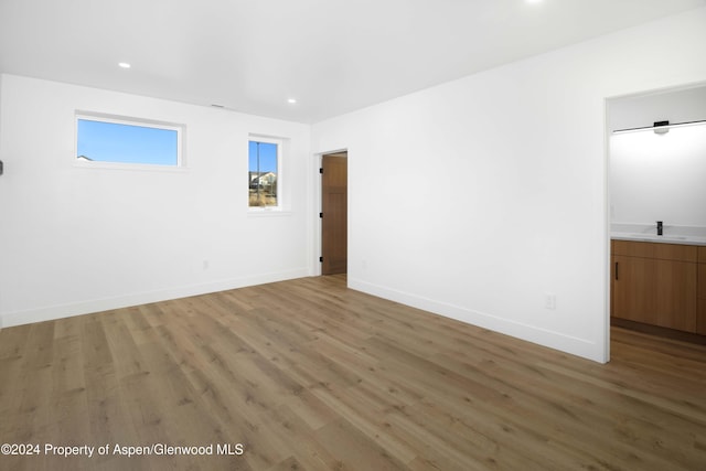 empty room with hardwood / wood-style flooring and sink