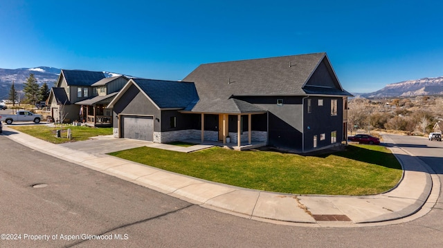 view of front of house with a mountain view, a garage, and a front yard