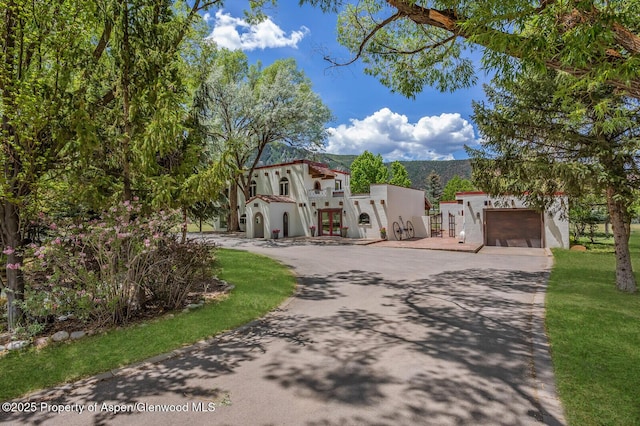 2459 Emma Rd, Basalt, CO 81621 - mediterranean / spanish-style home featuring stucco siding, driveway, french doors, and an attached garage