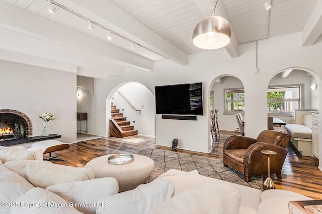 2459 Emma Rd, Basalt, CO 81621 - living area with rail lighting, hardwood / wood-style floors, arched walkways, baseboards, and beamed ceiling