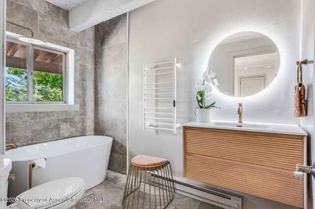 2459 Emma Rd, Basalt, CO 81621 - bathroom with radiator heating unit, a soaking tub, toilet, a towel warming rack, and vanity