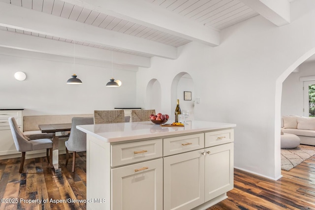 2459 Emma Rd, Basalt, CO 81621 - kitchen with arched walkways, dark wood finished floors, light countertops, white cabinetry, and wooden ceiling with exposed beams