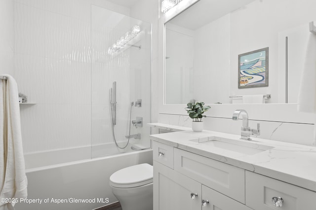 full bathroom with vanity, tiled shower / bath combo, and toilet