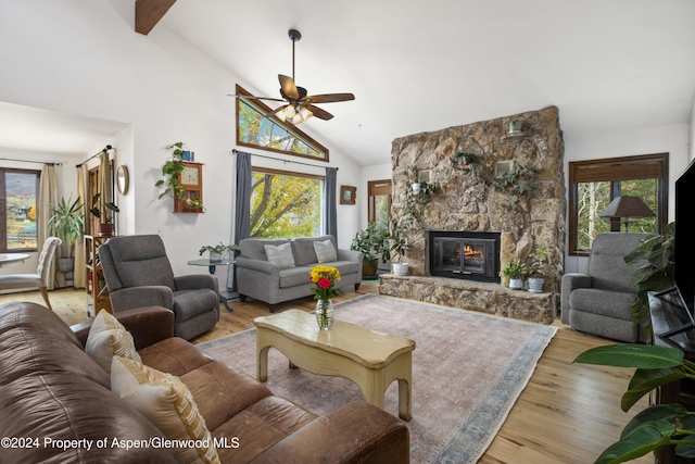 living room featuring plenty of natural light, beamed ceiling, a ceiling fan, and wood finished floors