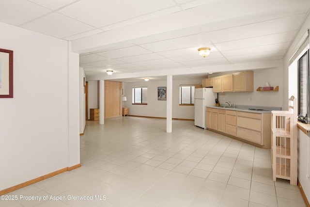 kitchen featuring a drop ceiling, sink, light brown cabinets, and white refrigerator