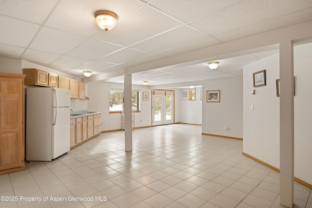 kitchen featuring light tile patterned flooring, a paneled ceiling, light brown cabinetry, white refrigerator, and french doors