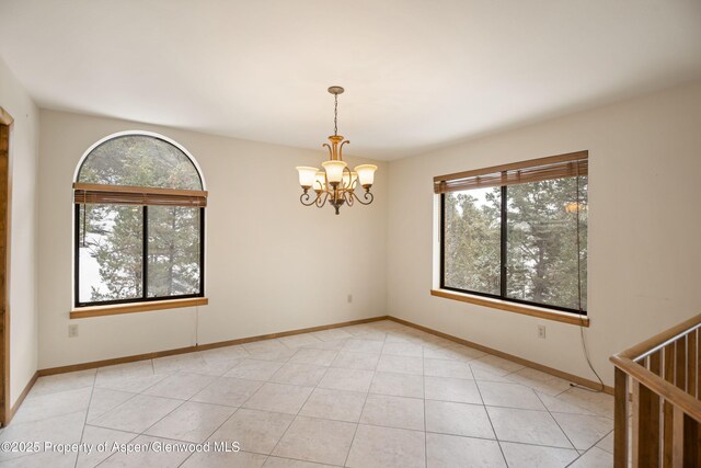 spare room featuring light tile patterned floors and a chandelier