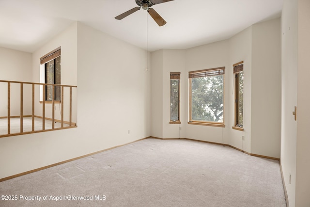 carpeted spare room with ceiling fan