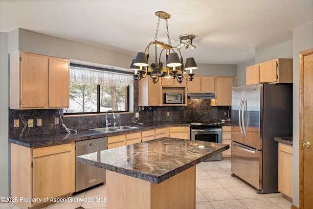 kitchen featuring sink, appliances with stainless steel finishes, an inviting chandelier, a center island, and light brown cabinetry