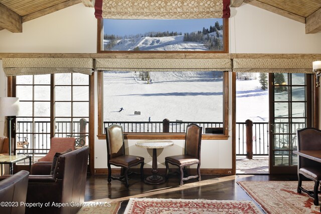 sunroom featuring lofted ceiling with beams, a wealth of natural light, and wooden ceiling