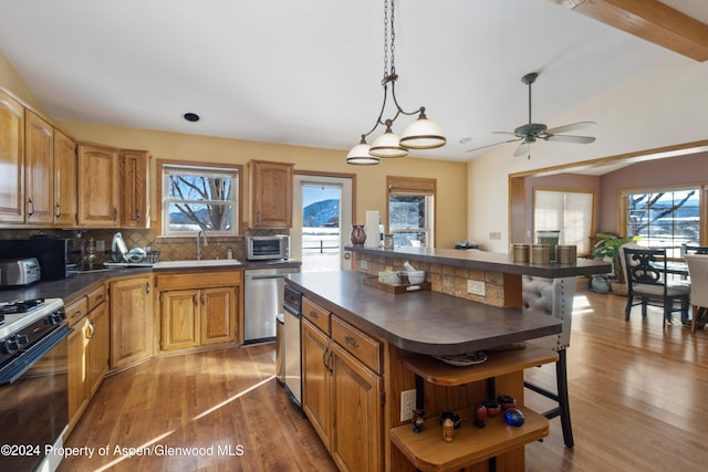 kitchen featuring a center island, backsplash, black gas stove, sink, and stainless steel dishwasher