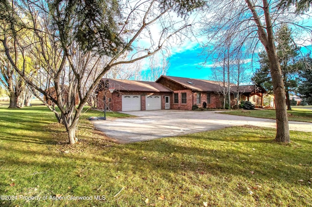 ranch-style house featuring a front yard and a garage