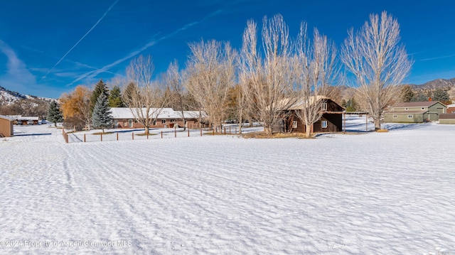 yard layered in snow featuring a mountain view