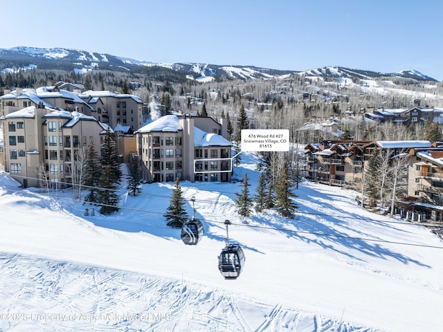 snowy aerial view featuring a mountain view