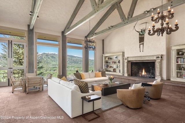 living room featuring a mountain view, high vaulted ceiling, a fireplace, beamed ceiling, and a notable chandelier