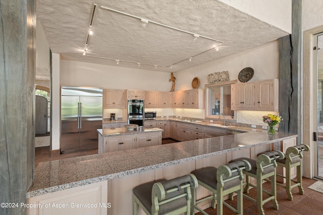 kitchen with a center island, kitchen peninsula, a breakfast bar area, and appliances with stainless steel finishes