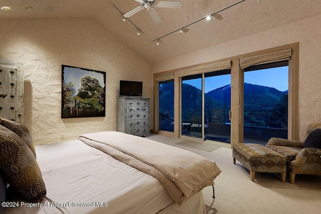 carpeted bedroom featuring track lighting, ceiling fan, and lofted ceiling