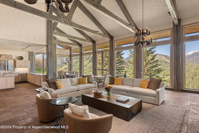 sunroom with a mountain view, lofted ceiling with beams, and an inviting chandelier